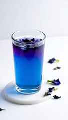 Refreshing Butterfly Pea Flower Tea - A Vibrant Blue Beverage with Ice and Dried Flowers.