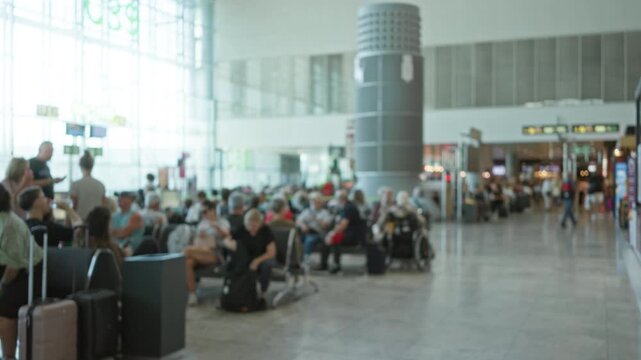 Blurred airport terminal defocused shallow bokeh background station wide airy waiting area with luggage; backdrop copyspace calm.