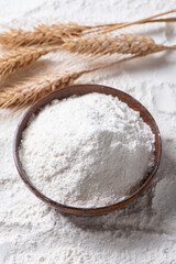 Close-up of white flour with wheat ears background.