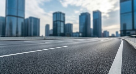 Obraz premium A wide, empty highway stretches into the distance, with a city skyline in the background.