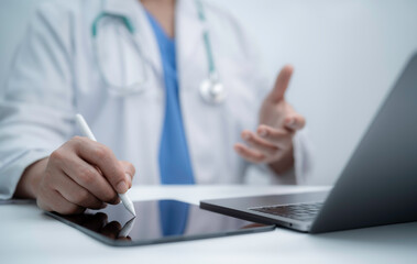 Healthcare professional using a digital pen on a tablet beside a laptop, highlighting modern medical documentation workflow efficient data entry and technology driven clinical information management