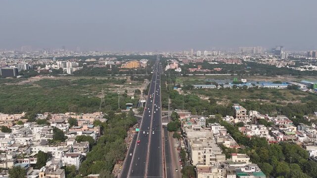Aerial view of Noida&rsquo;s bustling highway interchange surrounded by greenery and high-rise societies representing the city&rsquo;s evolving infrastructure.