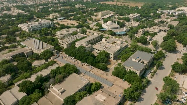 Drone ascending and receding over green and treed campus of NED University, finishing with a wider view of the entire campus and the sprawling city of Karachi.