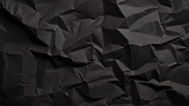 Dark black crumpled paper texture abstract background