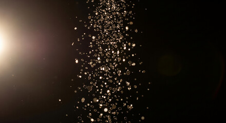 Obraz premium Sparkling particles of light shimmering against a dark backdrop, creating an ethereal and magical atmosphere with a bright lens flare