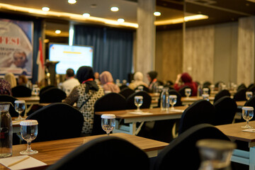 Seminar Audience Sitting in Conference Hall with Presentation Screen