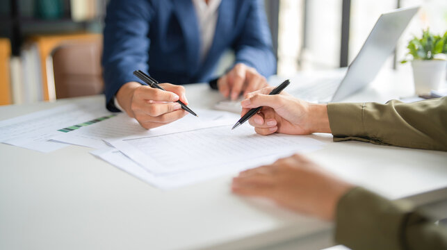 Businessmen working together at desk. - Powered by Adobe