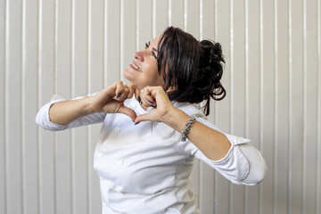 Mid Adult Woman chef making heart sign celebrating love