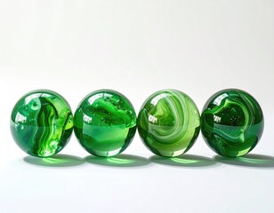 Four green glass spheres with unique swirling patterns, displayed in a row on a white background