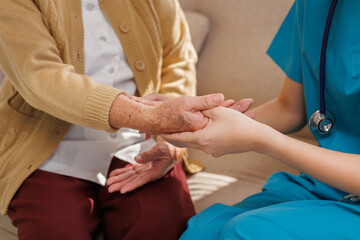 Caregiver providing comfort and support to an elderly person's hands. Empathy and compassion in home healthcare
