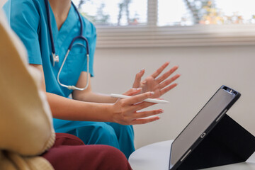 Nurse explaining health consultation results to a patient, using a digital tablet for visual aid and delivering modern healthcare