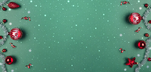 Christmas red glitter decorations with silver garland on green background. Merry Christmas and Happy New Year greeting card. Xmas and winter holidays, Christmas wide banner, top view