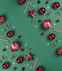 Christmas red glitter decorations on green background with glitter. Merry Christmas and Happy New Year greeting card. Xmas and winter holidays, top view