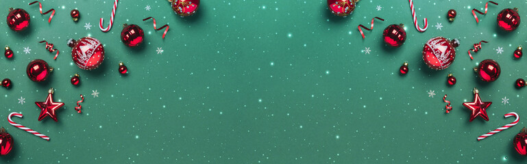 Christmas red glitter decorations on green background with lights, glitter. Merry Christmas and Happy New Year greeting card. Xmas and winter holidays, Christmas wide banner, top view