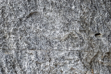 Rough gray stone texture with natural pores and detailed patterns, offering a raw and organic look, ideal for backgrounds, design surfaces, and natural themed projects