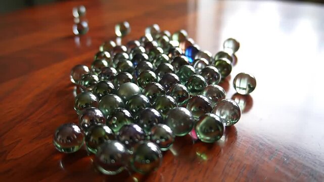 Rolling marbles scatter across a polished wooden surface, their reflections dancing in the light, creating a mesmerizing and calming effect for viewers