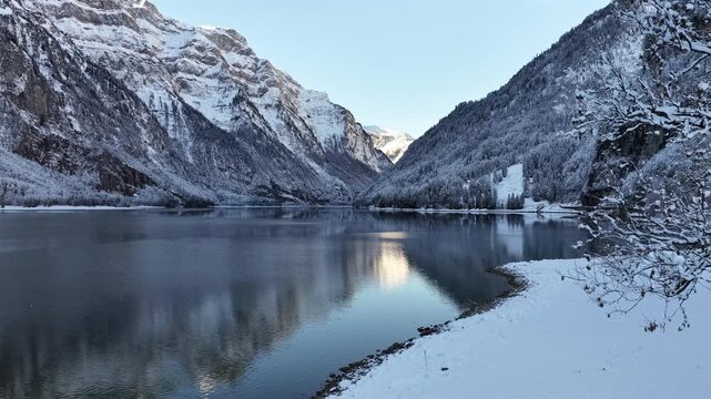winter landscape of kl&ouml;ntalersee with snowy alpine mountains in glarus switzerland