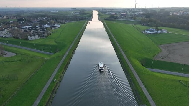 Aerial zoom out showing a boat traveling along the elevated canal in Str&eacute;py-Thieu, Le Roeulx at golden hour