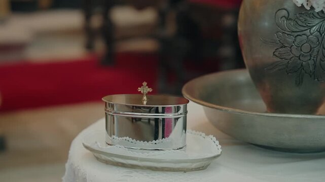 Close view of silver holy water vessel arranged for sacred ceremony