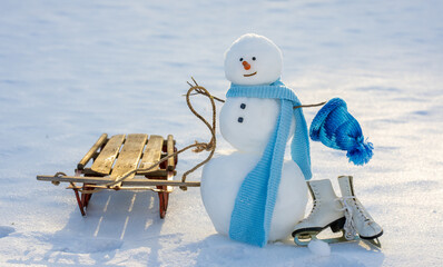 Snowman in winter sunshine. Snowman in snowy meadow. Winter snowman for Christmas greeting card....
