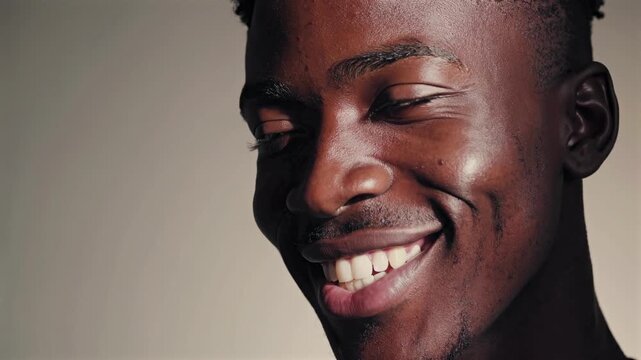 smiling confident male, black man portrait showcasing selfassured gentleman with captivating smile, intimate image of charismatic man displaying friendly smile and confident demeanor in sunlight