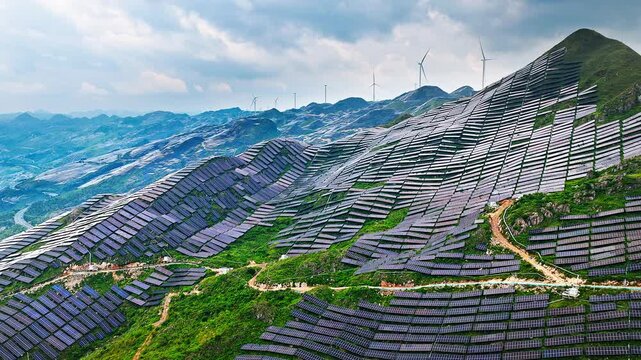 Aerial shot of solar panels and wind turbines on mountain