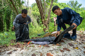 Two man tourists backpacking and relaxing on picnic in forest with camping equipment. Man pitching tent on camping trip. Vacation concept on a sunny summer day.