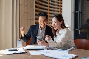 Businessmen celebrate news in smartphone
