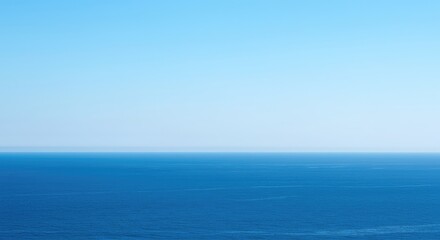 Fototapeta premium Endless blue ocean meeting a distant, slightly hazy horizon under a bright, clear summer sky. A minimalist, tranquil view ,water ,clear ,sunlight