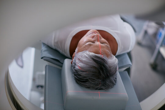 Healthcare, mri machine or patient in hospital for medical procedure, radiology or brain scan for diagnosis. Old woman, examine skull or tech for tumor screening, cancer detection or monitor growth