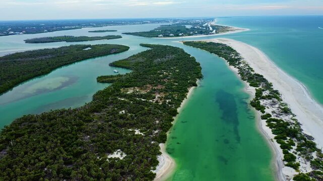Mangrove islands and bright sandy shoreline shape the winding green waterways leading toward Stump Pass, where clear Gulf shallows meet the long barrier stretch of Manasota Key on Florida&rsquo;s Gulf Coast