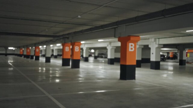 Blurred underground parking garage with orange marked pillars, shallow bokeh interior; background backplate copyspace template.