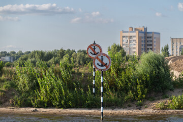 Mooring prohibition signs are prohibited. Interaction between urban development and natural landscapes near the riverbank.