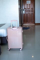 Suitcase standing by the bedside in modern hotel room, showcasing vacation arrival atmosphere