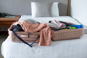 Traveler packing an open suitcase on the bed, organizing essentials for an upcoming journey
