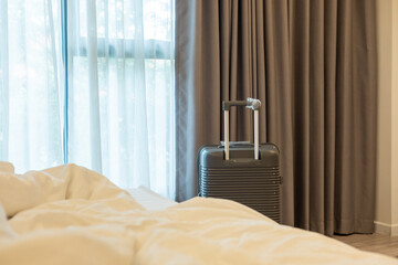 Large luggage positioned next to bedroom bed, highlighting relaxed travel lifestyle and planning