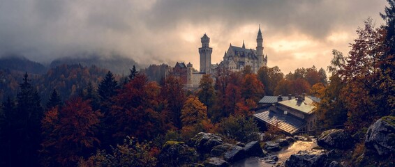 Castle on a hill surrounded by trees at sunset in autumn