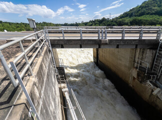 Sluice Gate Releasing Rushing Water Beneath Concrete Bridge.