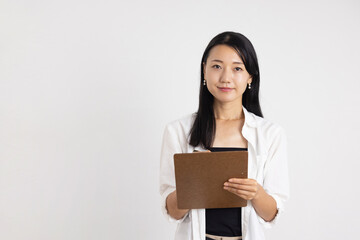 Obraz premium Smiling Woman Holding Clipboard and Pen Against White Background