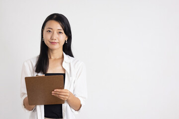 Obraz premium Smiling Woman Holding Clipboard and Pen Against White Background