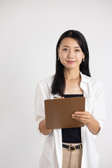 Obraz premium Smiling Woman Holding Clipboard and Pen Against White Background
