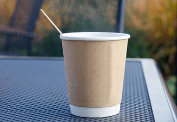Takeaway coffee cup on outdoor surface.