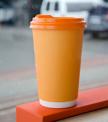 Takeaway coffee cup on outdoor surface.