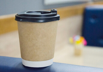 Takeaway coffee cup on outdoor surface.