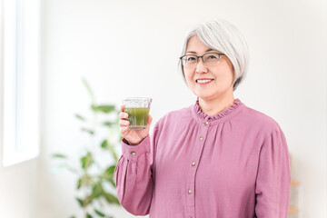 Senior women drinking green juice, green smoothies, and vegetable juice for health
