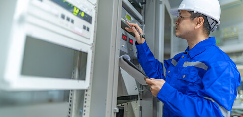 Electrical engineer woman checking voltage at the Power Distribution Cabinet in the control...