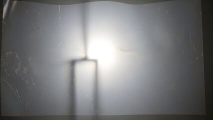 Bright light shining through a frosted or diffused surface, casting a rectangular shadow.