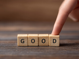 Good word concept wooden block letters finger touch push table positive message motivation closeup hand human wood cube typography text idea symbol sign communication encouragement success choice