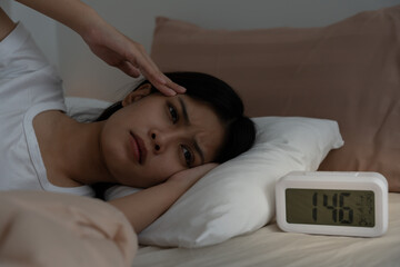 asian woman in bed late trying to sleep suffering insomnia, sleepless or scared in a nightmare, looking sad worried and stressed. Tired and headache or migraine waking up in the middle of the night.