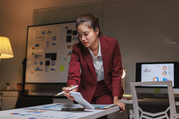 Young businesswoman analyzing business data working late at night